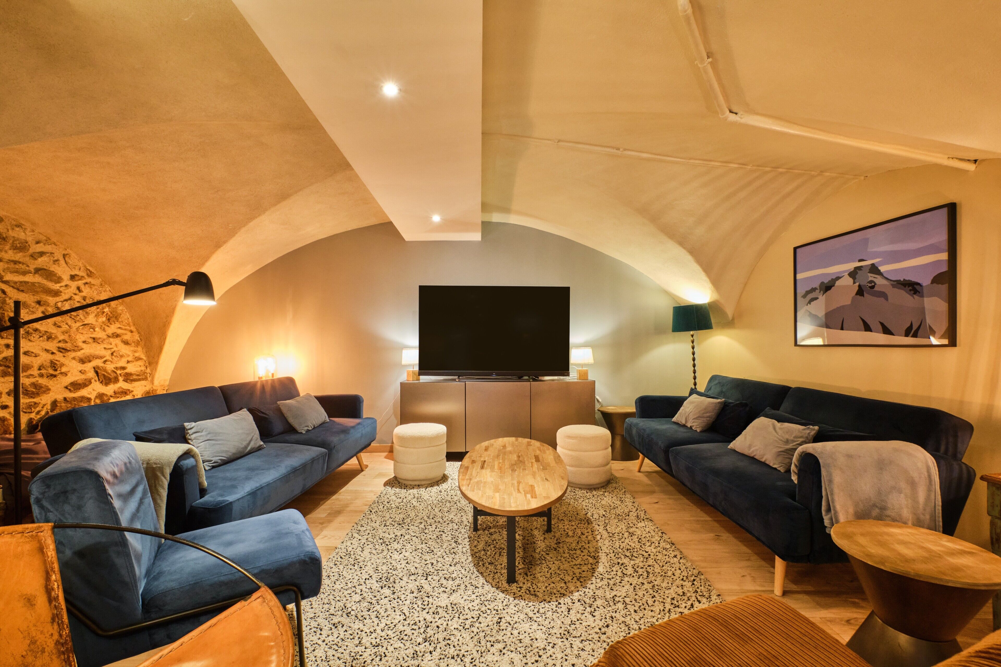 Un salon confortable avec deux canapés, une table basse et un téléviseur à écran plat.