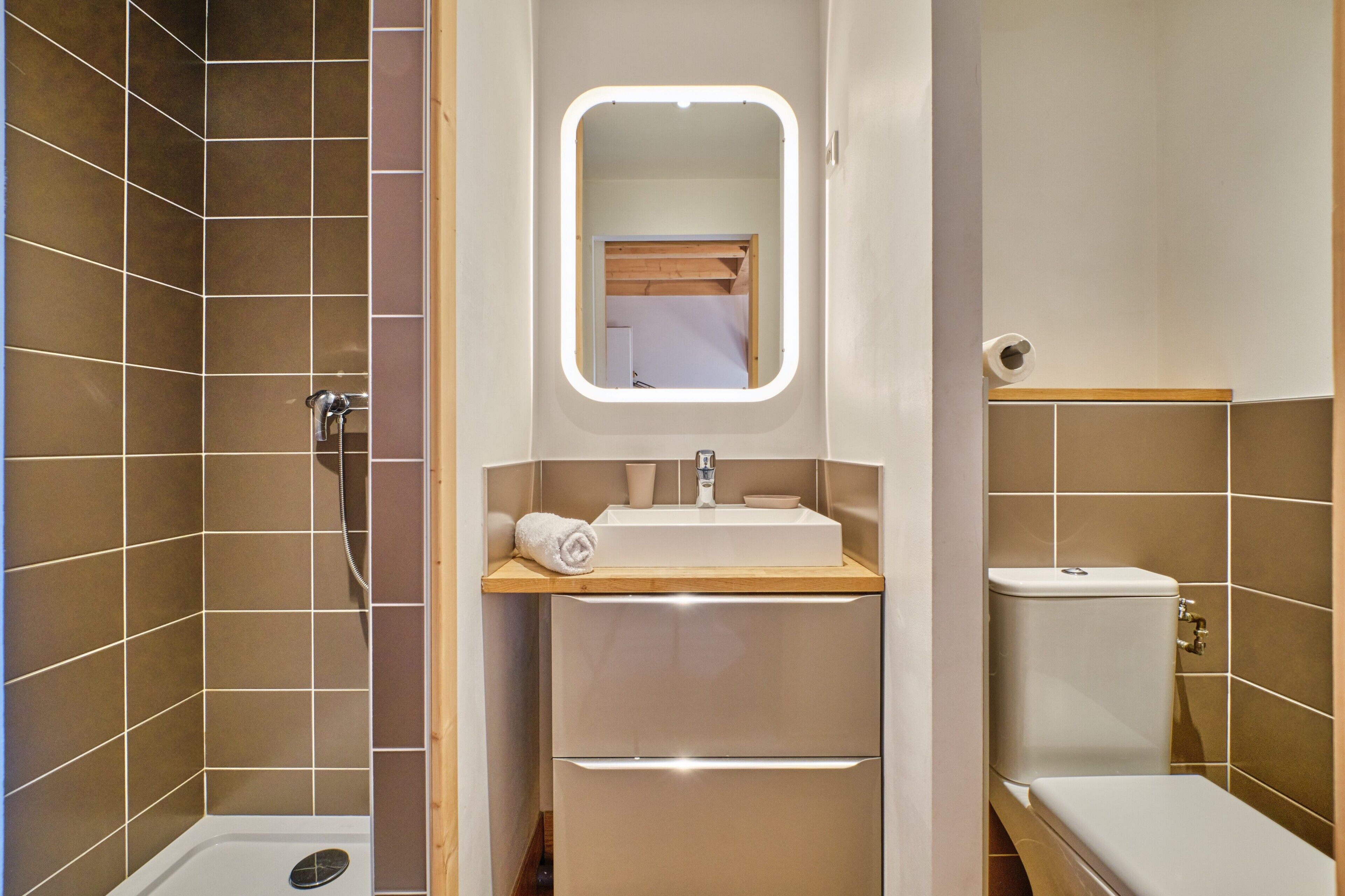 Une salle de bain équipée d’une douche, de toilettes, d’un lavabo et d’un miroir.