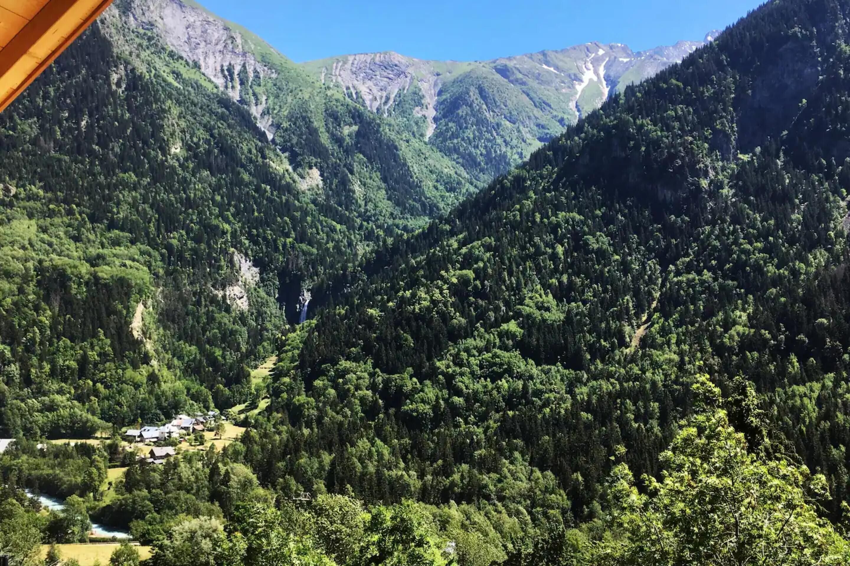 Un paysage montagneux, avec de vastes forêts et un petit village.