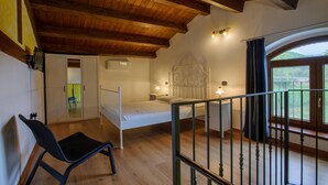 A bedroom with a wooden ceiling, a bed, a chair, and a window with a view of greenery. - Stunning home in Sassoferrato (Sassoferrato)