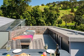 Una terrazza panoramica con zona pranzo, posti a sedere all'aperto e vista su un paesaggio verde.