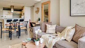 Una sala moderna con sofá, mesa de centro y comedor.