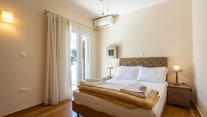 Un dormitorio con cama, lámparas de noche, ventilador de techo y ventana con cortinas.