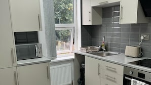 A modern kitchen with a microwave, sink, and stove. - City Chic Retreat In Birmingham (Birmingham)