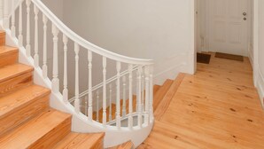 A spiral staircase with white balusters and wooden steps leading to an upper floor. - Liiiving in Porto - Silver Light Apartment (Porto)