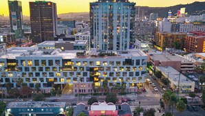 Um hotel com vários andares e design arquitetônico moderno, com um pátio central e múltiplas entradas.