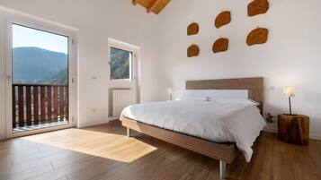 Une chambre avec un lit en bois, une fenêtre donnant sur une montagne et des éléments de décoration en bois sur les murs.