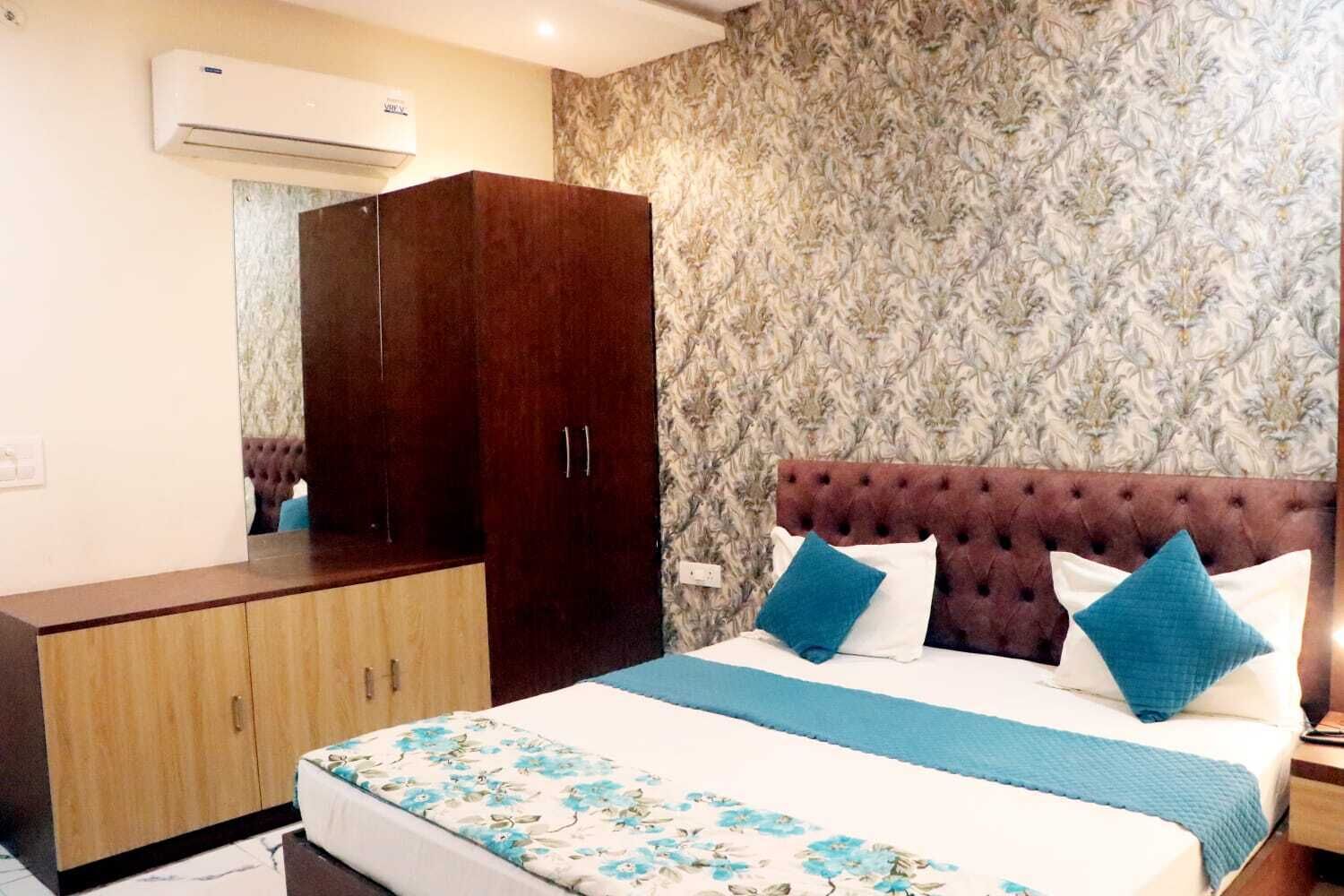 A bedroom with a bed, a wardrobe, and a wall-mounted air conditioner.
