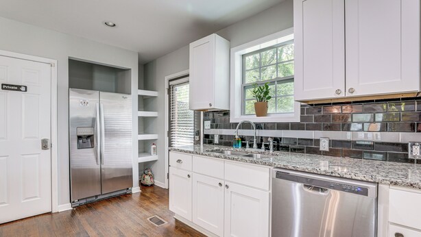 A modern kitchen with white cabinets, stainless steel appliances, and a granite countertop. - Private Hot Tub! Pet-friendly Hub By Mercedes-benz (Atlanta)