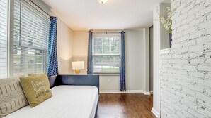 A bedroom with a bed, a nightstand, a lamp, and a window with curtains. - Private Hot Tub! Pet-friendly Hub By Mercedes-benz (Atlanta)