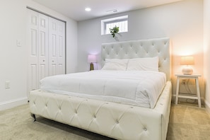 A bedroom with a large bed, a nightstand, a window with a plant, and a door. - 7 Mi to Baltimore: Maryland Gem w/ Shared Yard! (Baltimore)