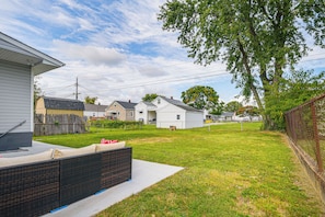 A residential backyard with a patio, a wooden fence, and houses in the background. - 7 Mi to Baltimore: Maryland Gem w/ Shared Yard! (Baltimore)