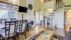 A spacious living area with a fireplace, wooden flooring, and a staircase leading to an upper level. - 2 Mi to Ober Mountain: Gatlinburg Condo w/ Balcony (Gatlinburg)