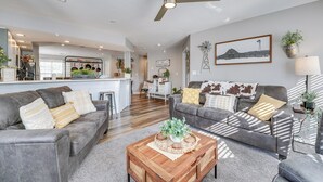 A modern living room with two grey sofas, a wooden coffee table, and a ceiling fan. - Condo w/ Pool ~ 2 Mi to Table Rock Lake! (Branson)