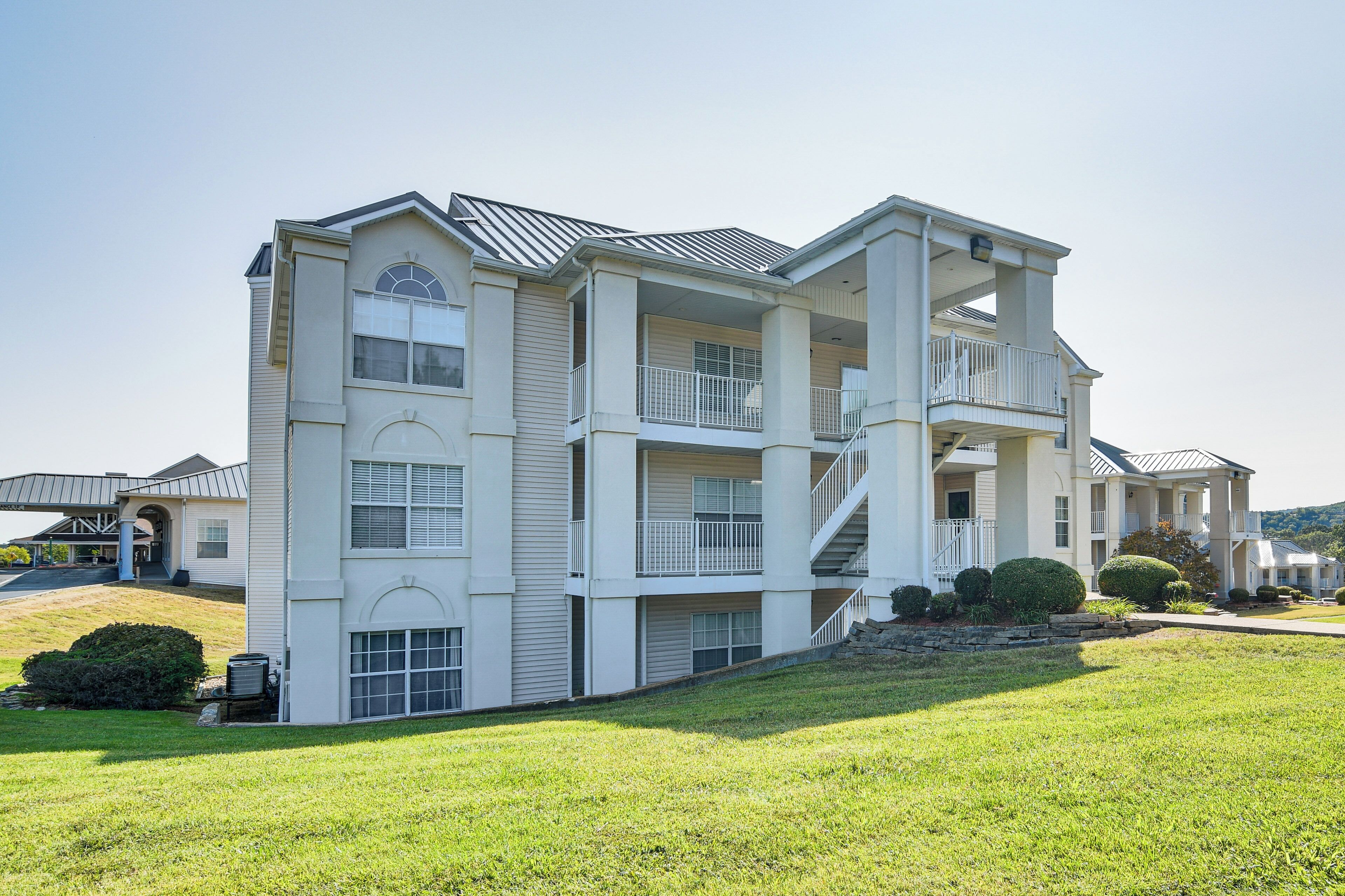 A multi-story residential building with a central courtyard, balconies, and a covered entryway.