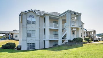 A multi-story residential building with a central courtyard, balconies, and a covered entryway.