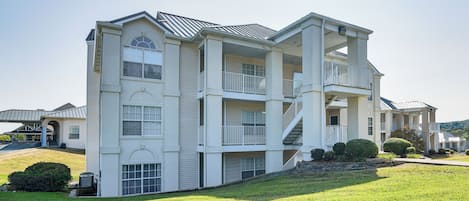 A multi-story residential building with a central courtyard, balconies, and a covered entryway.
