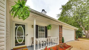 Ein Haus mit Veranda, Fußmatte und einem kleinen Garten.