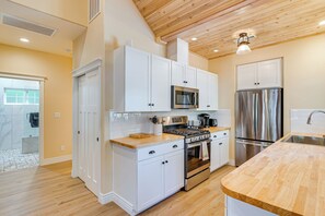 A modern kitchen with white cabinetry, stainless steel appliances, and a wooden countertop. - Auburn Farmhouse w/ Fireplace, Close to Wineries (Auburn)