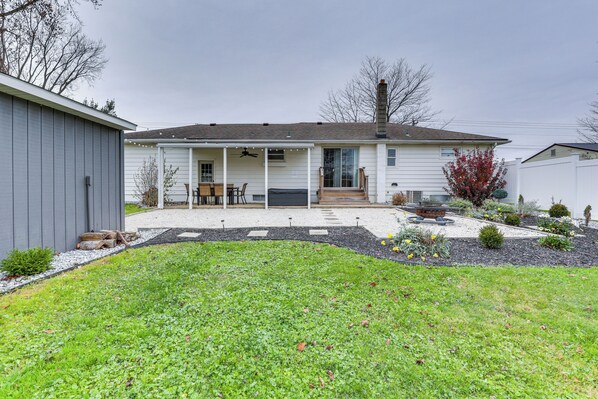 A single-story house with a covered patio, a front door, and a small front yard with a lawn and a flower bed.