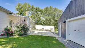A residential property with a covered patio, a garage, and a well-maintained lawn. - Wooster Family Home w/ Yard & Fire Pit! (Wooster)