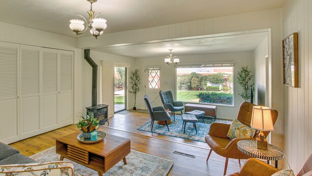 A spacious living room with a fireplace, comfortable seating, and large windows offering a view of the outdoors. - Walk to Downtown: Brigham City Family Home (Brigham City)