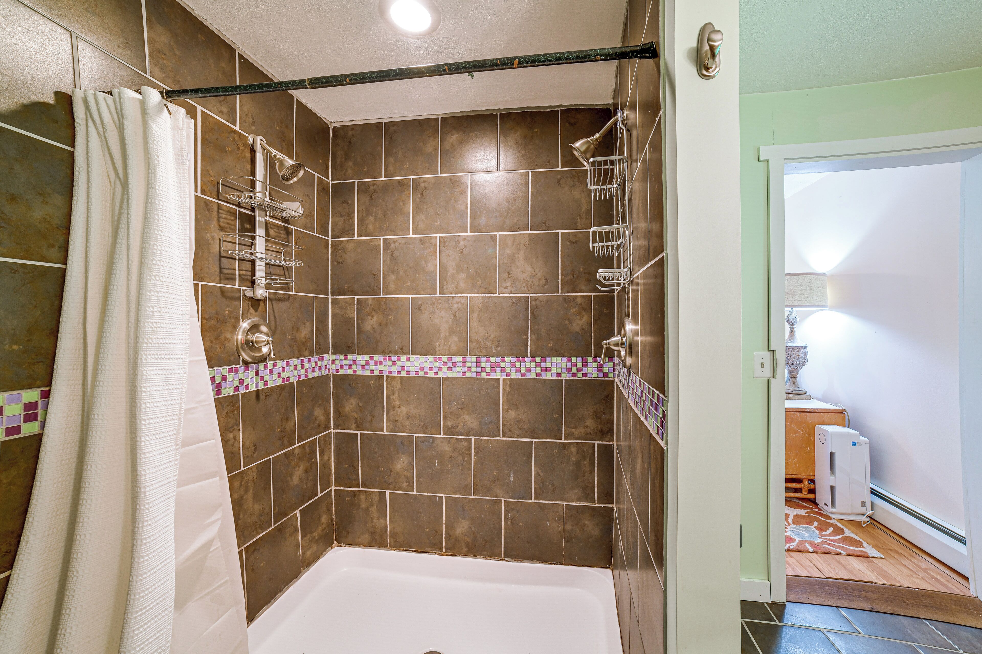 A bathroom with a shower, a bathtub, and tiled walls.