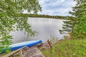 A calm lake with a wooden dock and a blue canoe. - Home w/ Private Dock Near Colgate University (Hamilton)