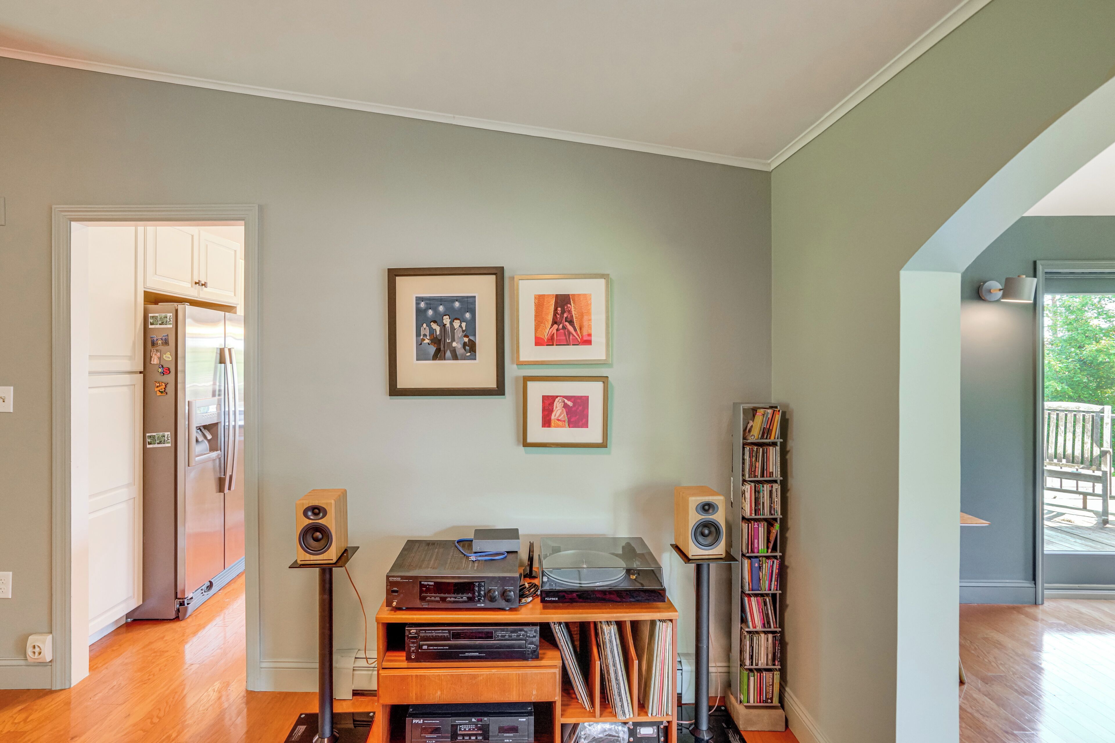 A living room with a wooden entertainment center, a bookshelf, and framed pictures on the wall.