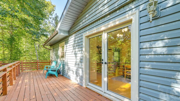A wooden deck with a sliding glass door leading to an outdoor seating area. - Home w/ Trail Access & Fire Pit in Bella Vista! (Bella Vista)