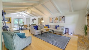 A spacious living room with a high ceiling, a sofa set, a coffee table, and a rug. - Home w/ Trail Access & Fire Pit in Bella Vista! (Bella Vista)