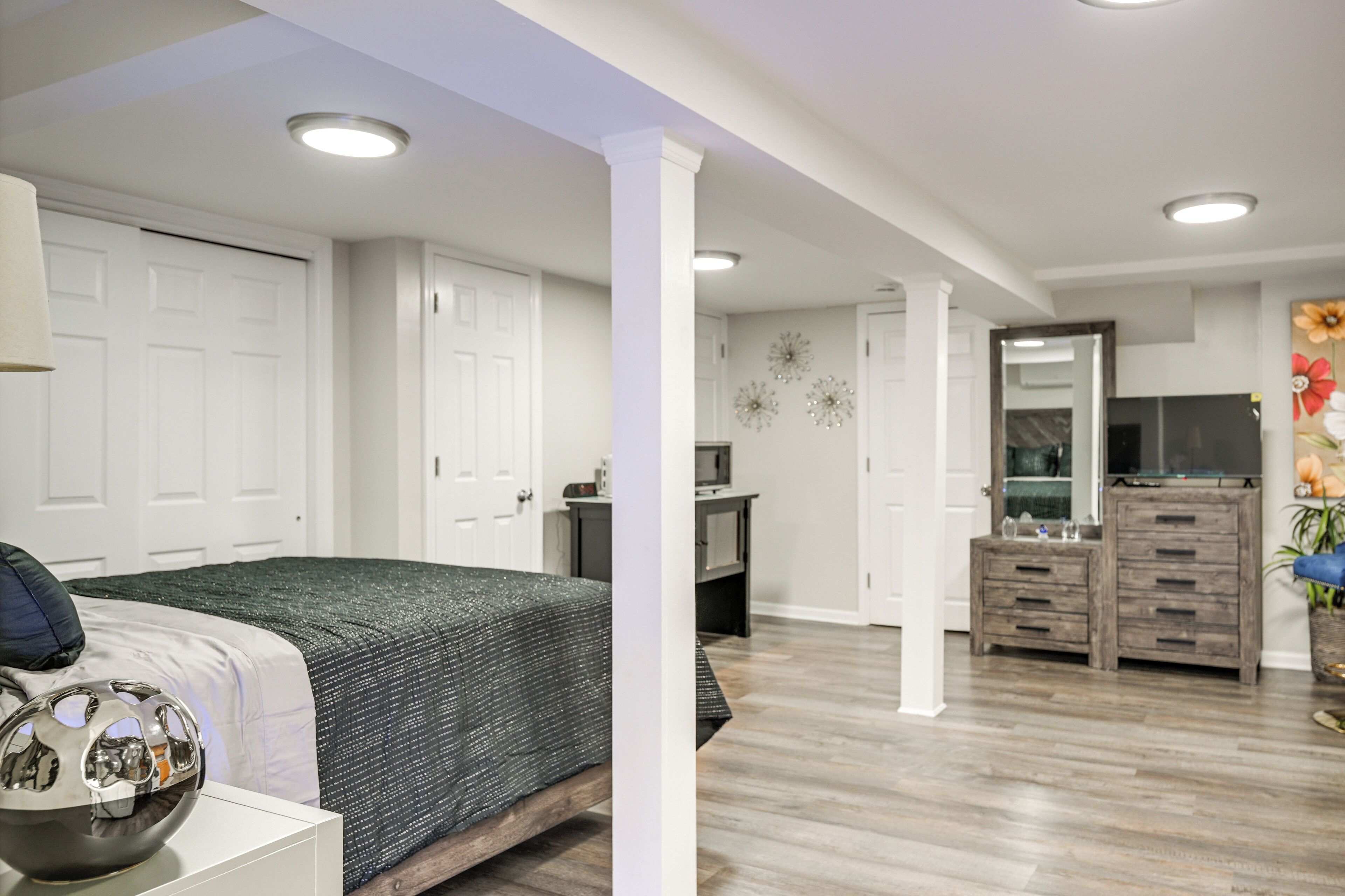 A bedroom with a bed, dresser, and vanity.