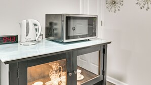 Eine Küchenarbeitsplatte mit einer Mikrowelle, einer Kaffeemaschine und einer digitalen Uhr, die 9:43 Uhr anzeigt.
