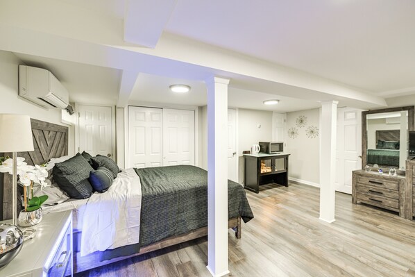 Un dormitorio moderno con cama, mesita de noche y cómoda.
