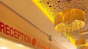 A reception area with a Shell logo, a receptionist, and a decorative ceiling.