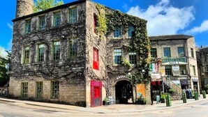 A historic building with a prominent chimney, a red door, and a sign for Hebden Bridge Mill. - Woodland View by the Canal Hebden Bridge (Hebden Bridge)