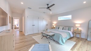 A bedroom with a bed, bedside tables, a ceiling fan, and a window. - The Peacock Place – Family Home w/Heated Pool (Tampa)