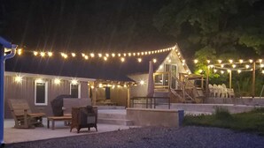 A building with outdoor seating and string lights. - Our Happy Place: Hot Tub & Trail Access: STR25-00043 (Tory Hill)