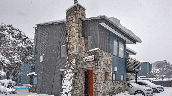 En moderne bygning med en stenfassade og et skilt, hvor der står "Powder".