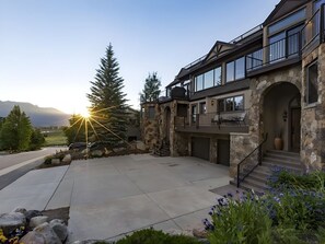 A modern house with a stone facade, large windows, and a spacious front yard. - Uncover Luxury by the Lake with the panoramic views from a rooftop deck! (Dillon)
