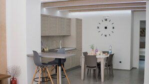 Et moderne køkken med spiseplads, med et stort vægur og et minimalistisk design.