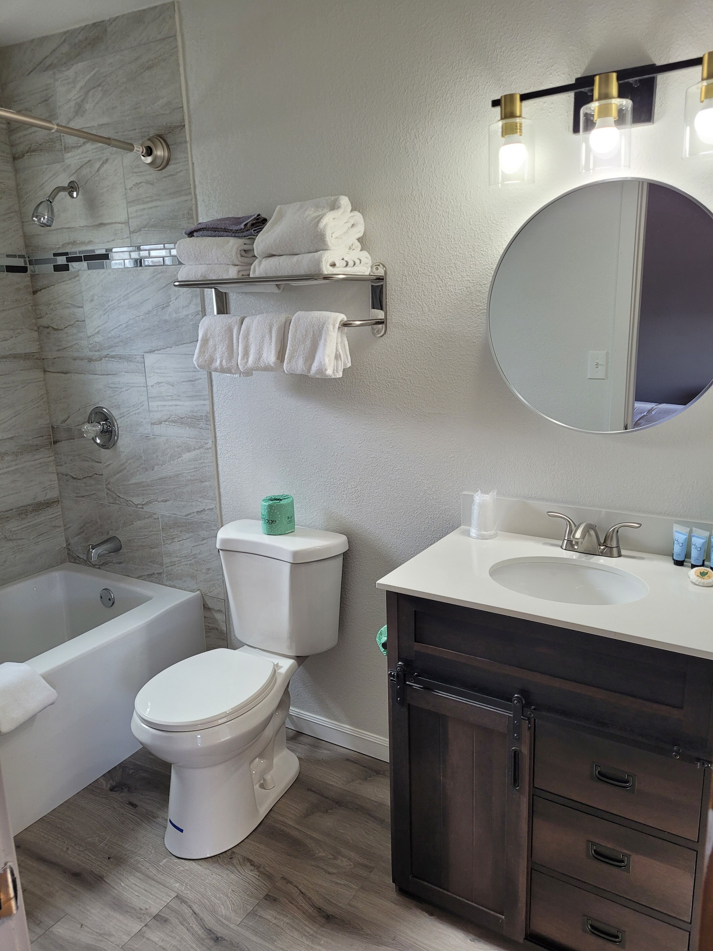 A modern bathroom with a bathtub, toilet, and vanity.