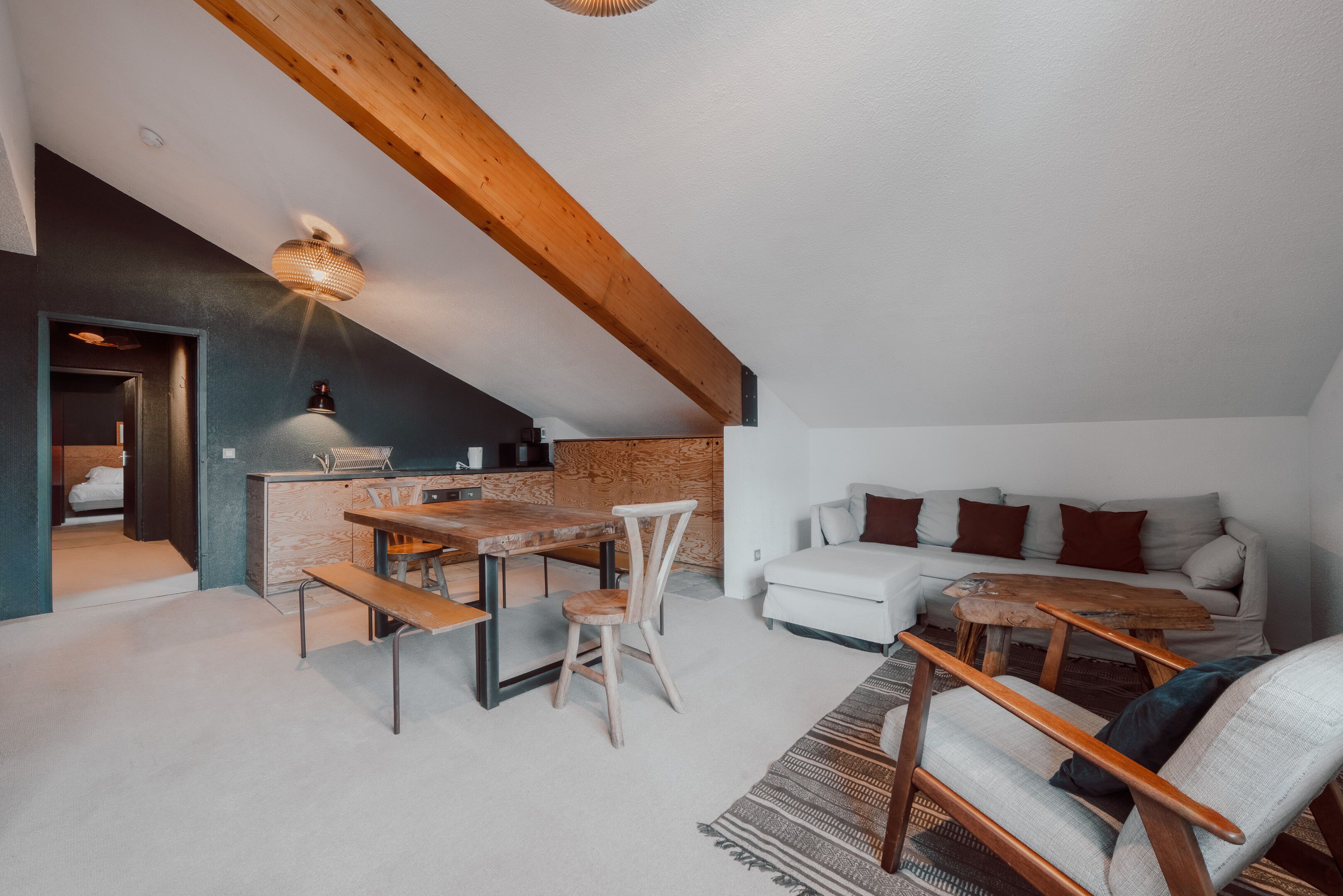 A cozy loft-style living space with a dining area, a kitchen, and a seating area.