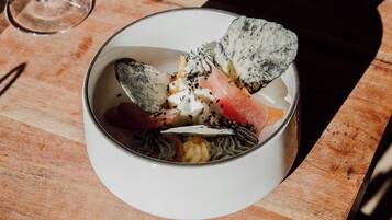 A bowl of dessert with various toppings on a wooden table.