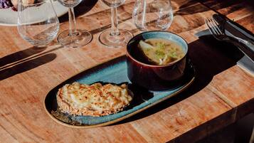 Una mesa de madera con un plato azul que contiene un plato y un cuenco de sopa.