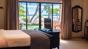 Un dormitorio con cama, escritorio y vista a la playa.