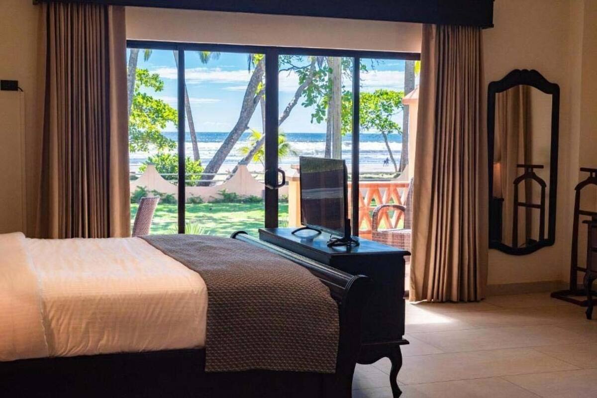 Un dormitorio con cama, escritorio y vista a la playa.