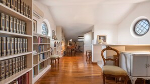 A library with wooden floors, bookshelves, a desk, and chairs. - Villa Le Fontanelle In Forte Dei Marmi (Forte dei Marmi)