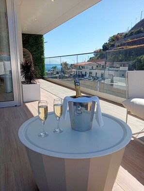 A balcony with a table, two glasses, and a champagne bucket. - Serendipity Green - luxury flat in the centre of Ribeira Brava (Ribeira Brava)