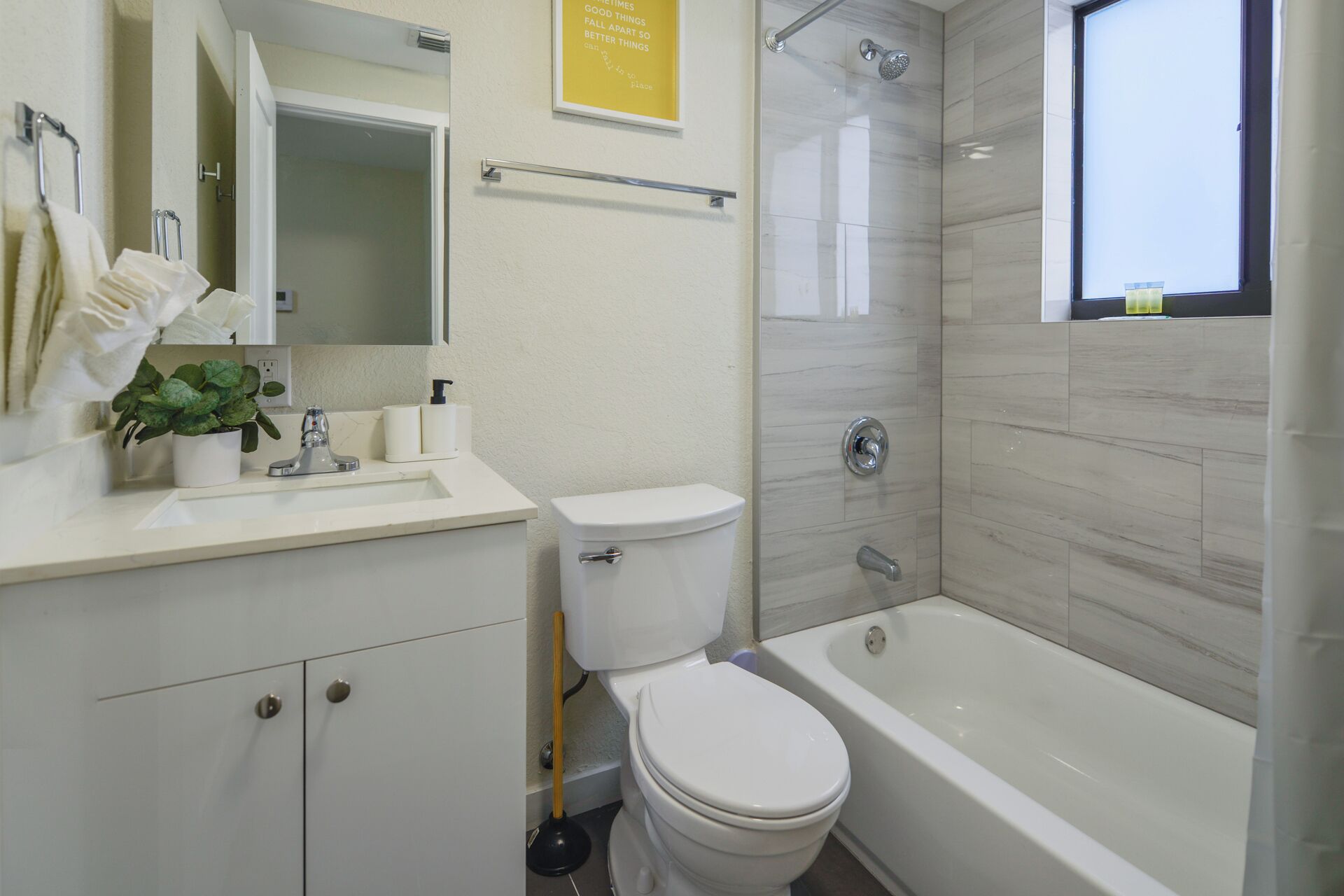 A modern bathroom with a toilet, sink, and bathtub.